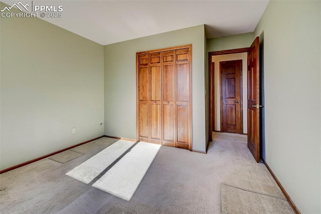 unfurnished bedroom with light carpet and a closet