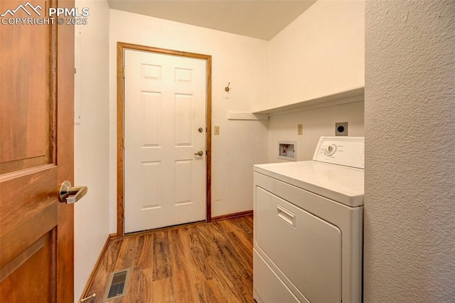 laundry area featuring hardwood / wood-style flooring and washer / dryer