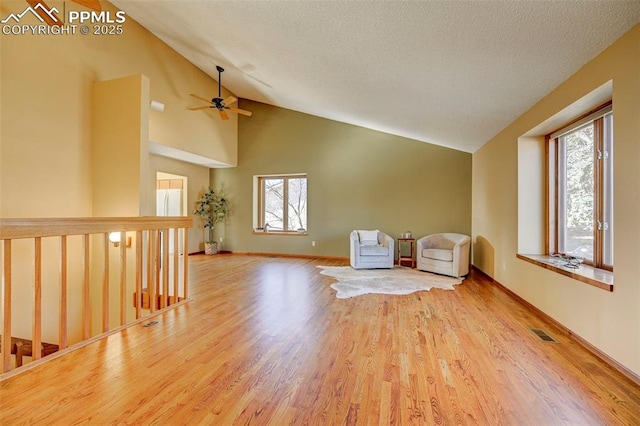 unfurnished room with a textured ceiling, light hardwood / wood-style floors, vaulted ceiling, and ceiling fan