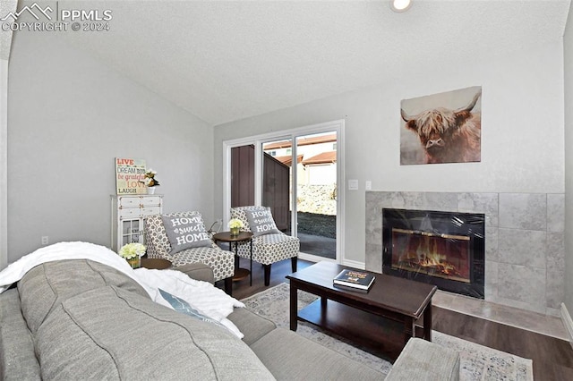 living room featuring hardwood / wood-style floors, vaulted ceiling, and a premium fireplace