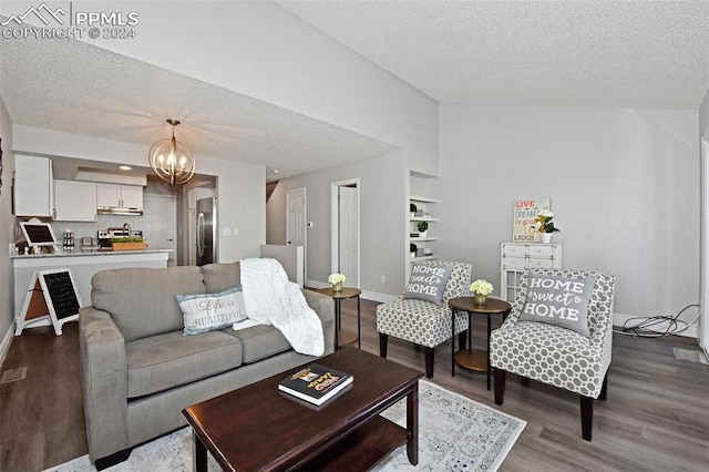 living room featuring a textured ceiling, hardwood / wood-style floors, and an inviting chandelier