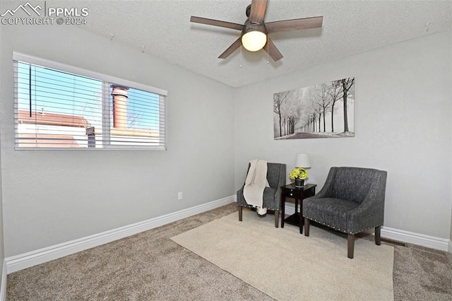 living area with carpet floors, a textured ceiling, and ceiling fan