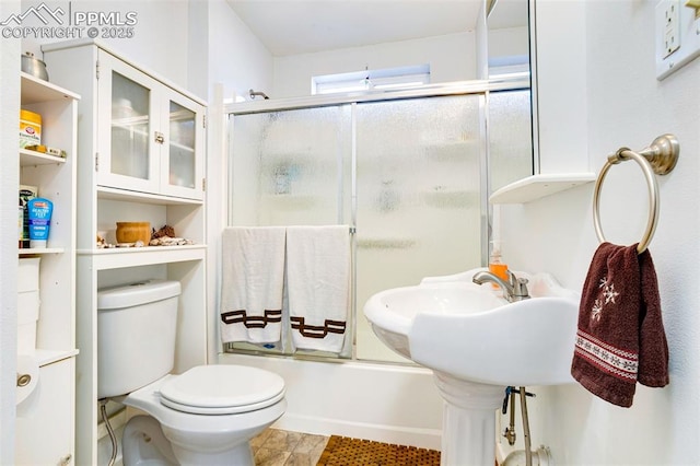 bathroom with toilet and enclosed tub / shower combo