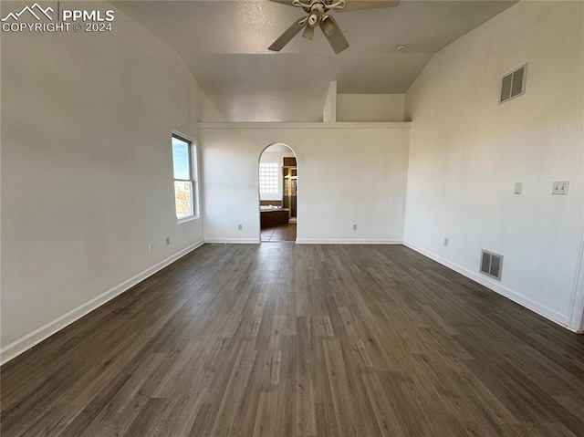 empty room featuring ceiling fan, dark wood-type flooring, and vaulted ceiling