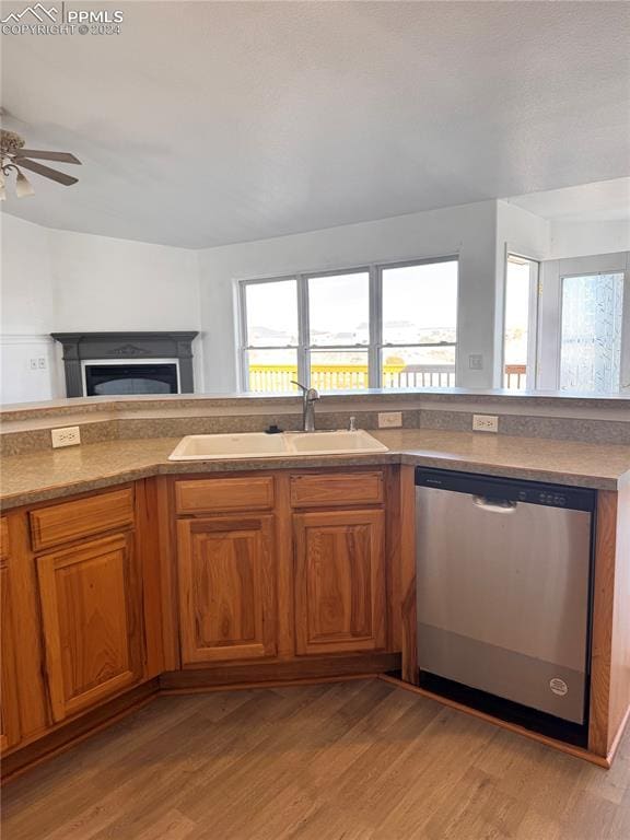 kitchen with a wealth of natural light, sink, stainless steel dishwasher, and light wood-type flooring