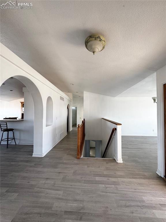 hallway with dark hardwood / wood-style flooring and a textured ceiling