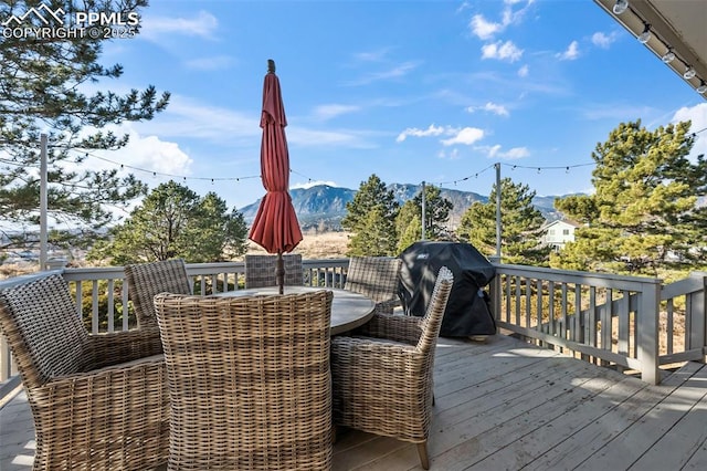 wooden deck with a grill and a mountain view