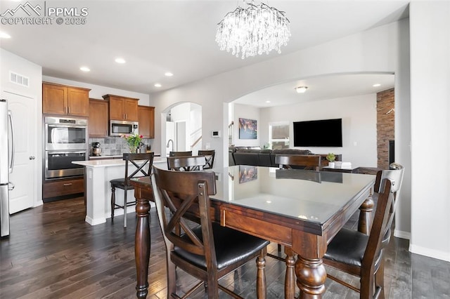 dining area with a notable chandelier and dark hardwood / wood-style floors