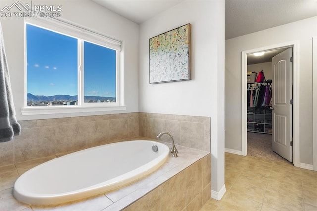 bathroom featuring tiled tub and tile patterned flooring