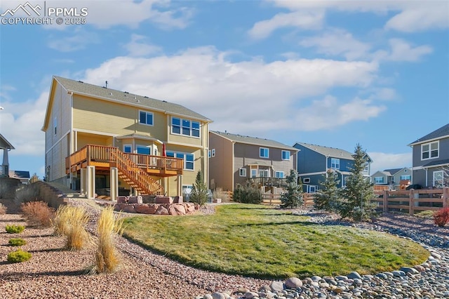 rear view of house featuring a deck and a yard