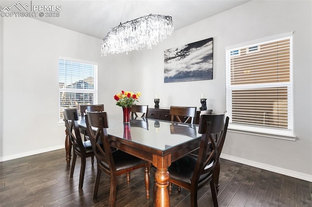 dining space with dark wood-type flooring and an inviting chandelier