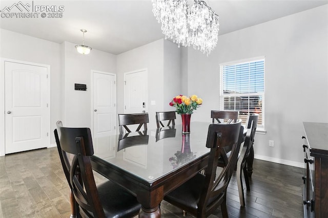 dining space featuring dark hardwood / wood-style flooring and a notable chandelier