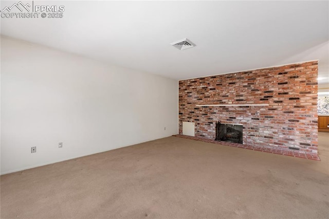 unfurnished living room featuring carpet and a brick fireplace