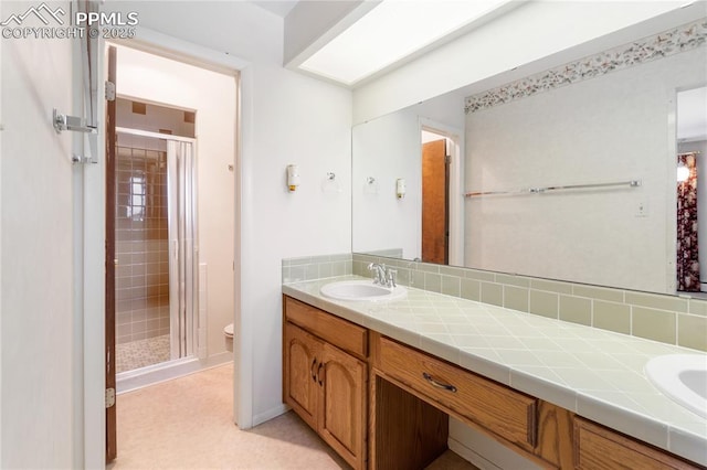 bathroom featuring vanity, toilet, and a shower with shower door