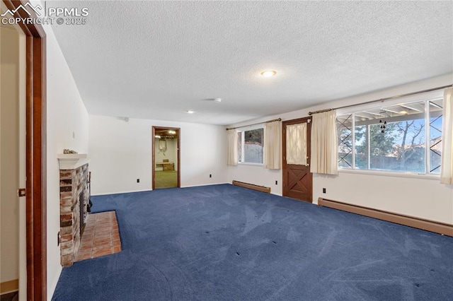 basement with baseboard heating, a textured ceiling, and a brick fireplace