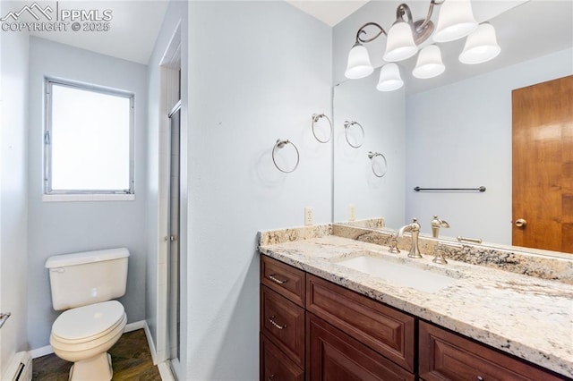 bathroom with vanity, toilet, a shower with shower door, and a baseboard heating unit