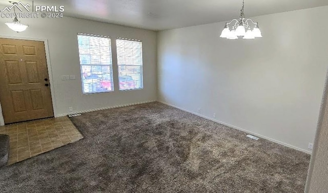 foyer with dark colored carpet and an inviting chandelier