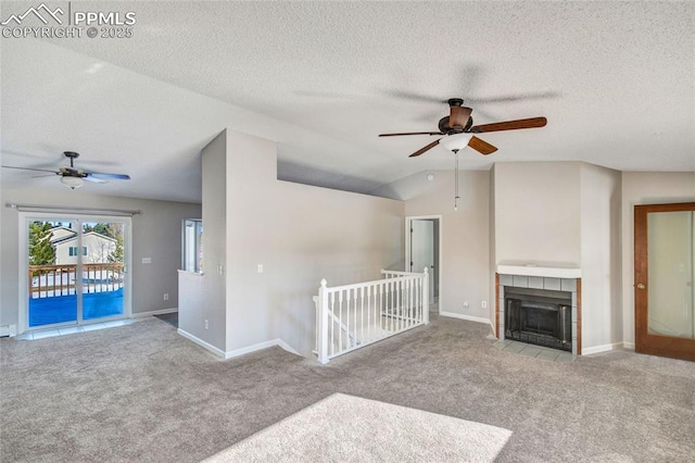 unfurnished living room featuring vaulted ceiling, light colored carpet, a textured ceiling, and a fireplace