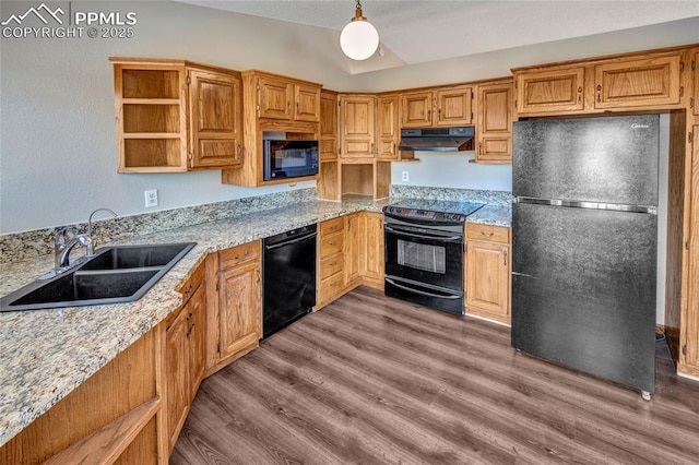 kitchen featuring pendant lighting, sink, light stone counters, black appliances, and light wood-type flooring