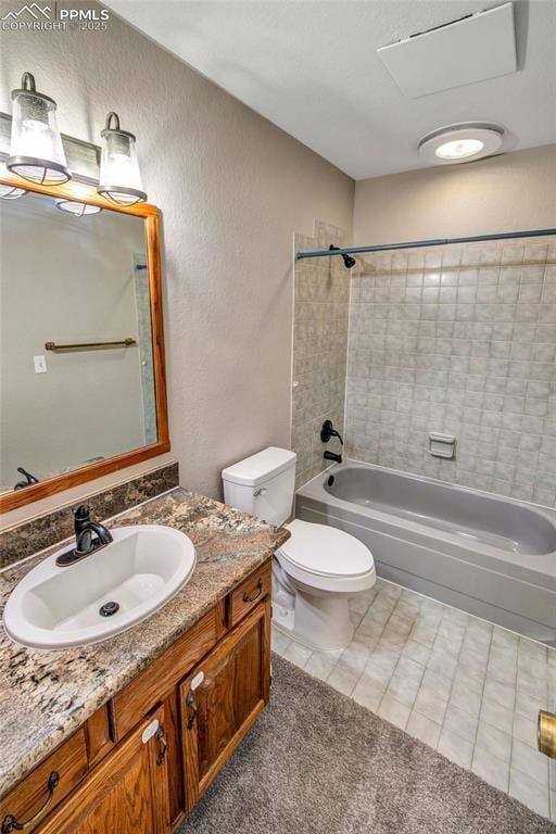 full bathroom featuring vanity, toilet, tiled shower / bath combo, and tile patterned flooring