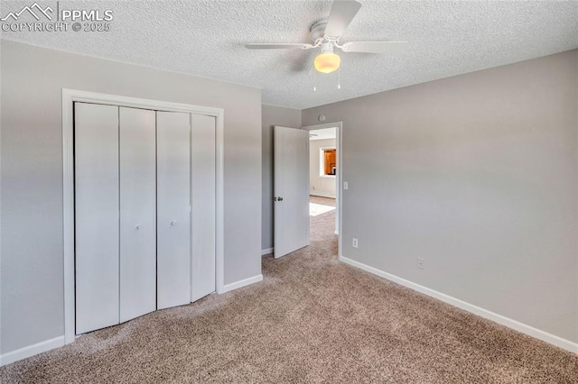 unfurnished bedroom featuring ceiling fan, a closet, light carpet, and a textured ceiling