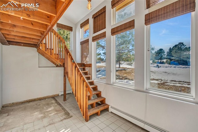 staircase with a baseboard heating unit and a wealth of natural light