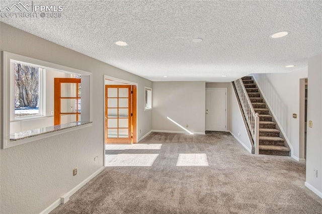 carpeted empty room featuring a textured ceiling