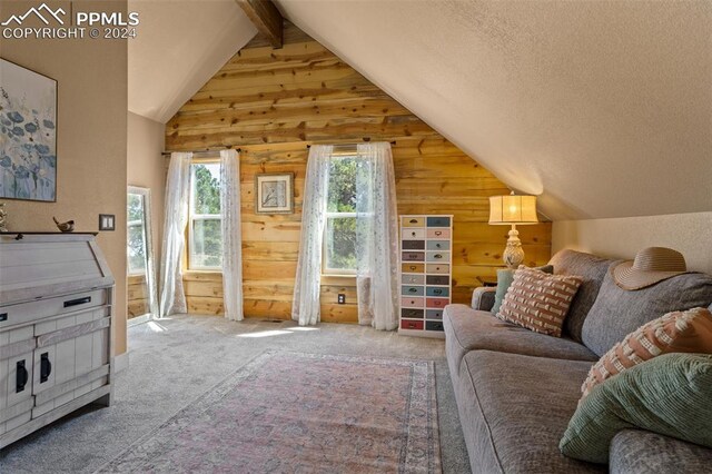 carpeted living room featuring vaulted ceiling with beams, wood walls, and a textured ceiling