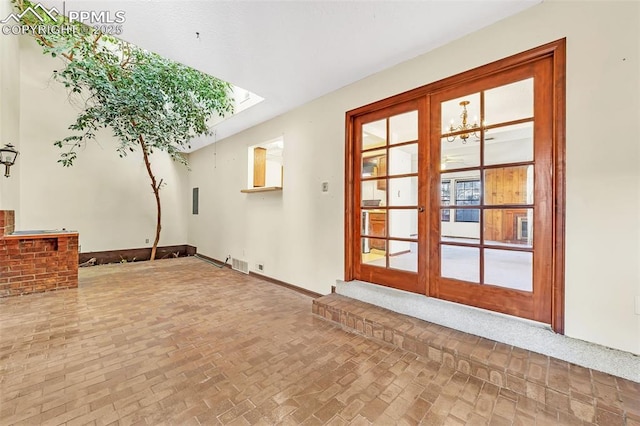 interior space with french doors, a skylight, and a notable chandelier