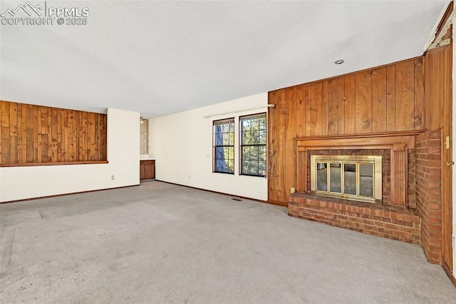 unfurnished living room featuring light colored carpet, wooden walls, and a brick fireplace