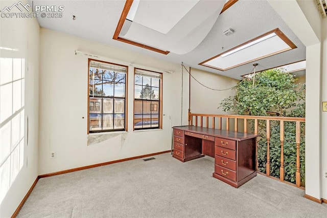 office space featuring light colored carpet and a skylight