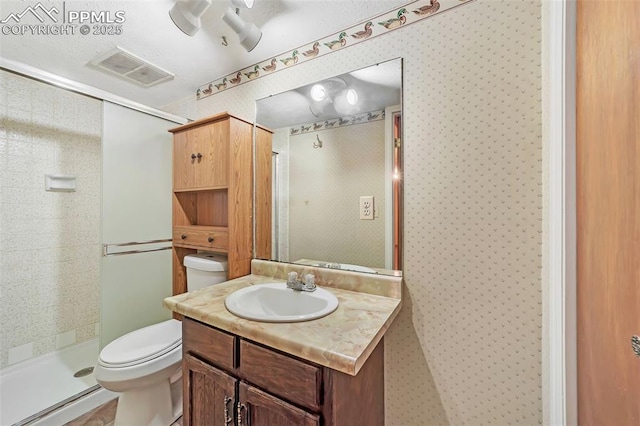 bathroom featuring vanity, toilet, and a shower with shower door