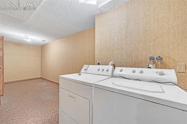 laundry area featuring washing machine and dryer and a textured ceiling