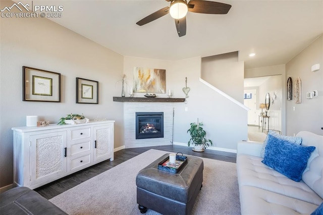 living room featuring ceiling fan and dark wood-type flooring