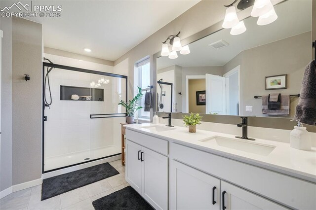 bathroom with tile patterned flooring, vanity, walk in shower, and a notable chandelier