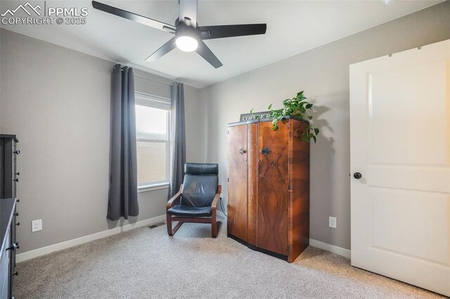 sitting room featuring light carpet and ceiling fan