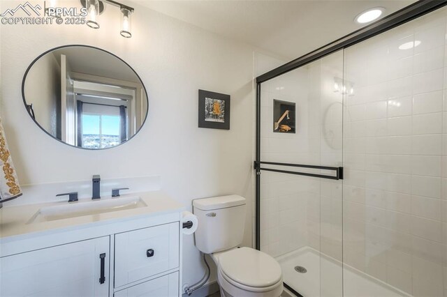 bathroom with vanity, an enclosed shower, and toilet