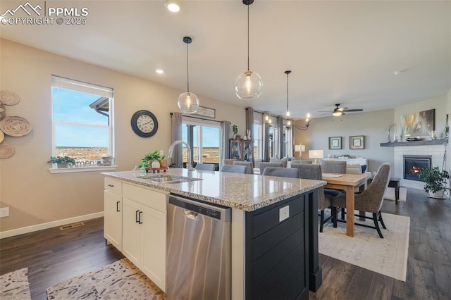 kitchen featuring ceiling fan, a kitchen island with sink, sink, dishwasher, and white cabinetry