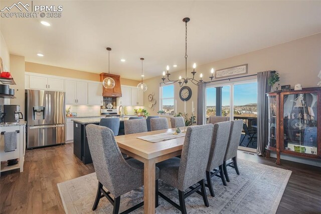 dining space with dark hardwood / wood-style floors, a notable chandelier, and sink