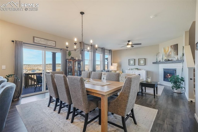 dining space with ceiling fan with notable chandelier and dark wood-type flooring