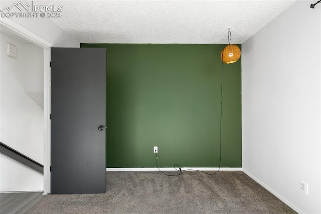 carpeted empty room featuring a textured ceiling