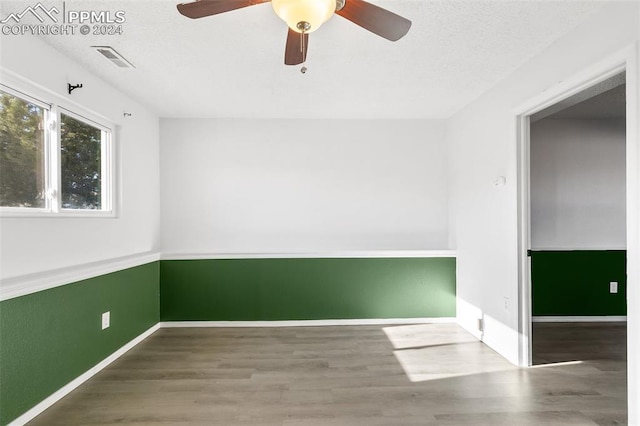 empty room featuring wood-type flooring and ceiling fan