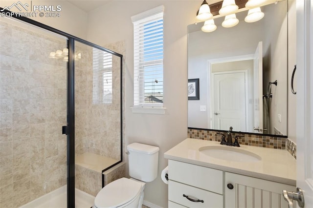 bathroom featuring vanity, toilet, walk in shower, and tasteful backsplash