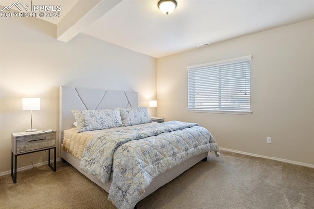 bedroom with beamed ceiling and carpet floors