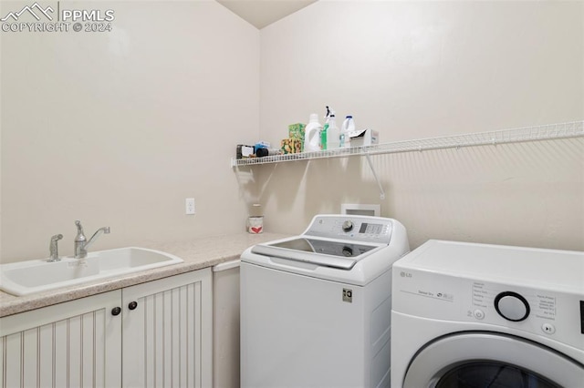 laundry room featuring cabinets, independent washer and dryer, and sink