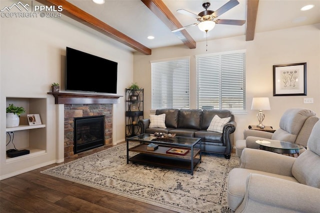 living room featuring built in shelves, ceiling fan, beam ceiling, a fireplace, and hardwood / wood-style floors