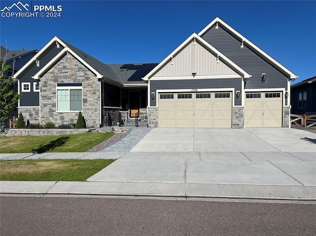 craftsman-style home with solar panels and a garage