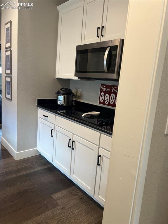 kitchen featuring white cabinets and dark hardwood / wood-style floors