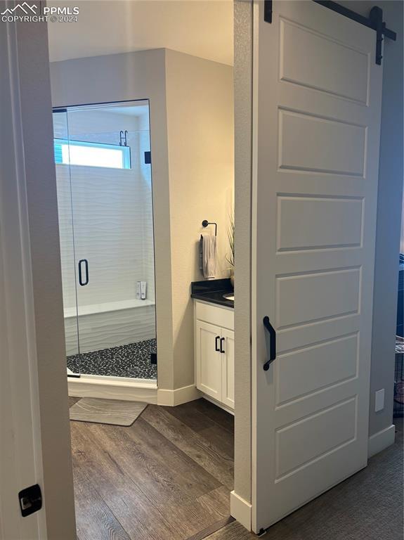 bathroom featuring hardwood / wood-style floors, vanity, and an enclosed shower