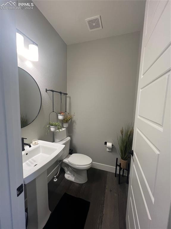 bathroom featuring toilet and wood-type flooring